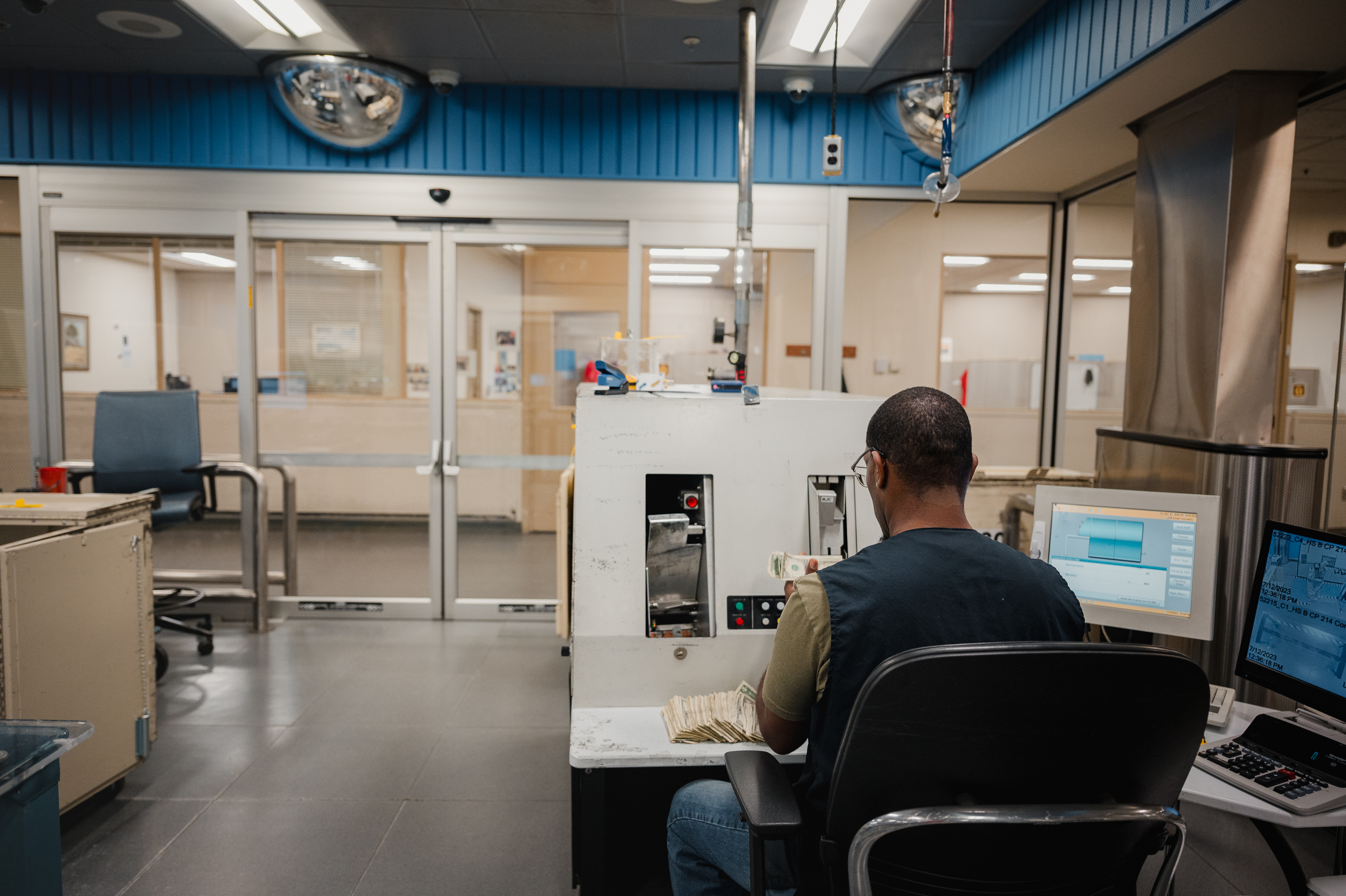 BALTIMORE, MD - JULY 12, 2023:  An employee works at the reconciliation station to manually process currency at the Federal Reserve Bank of Richmond in Baltimore, MD. on Wednesday, July 12, 2023. Fit currency is any currency the currency processor deems as adequate to put back into the public. (Photo by Hannah Yoon for The Washington Post)